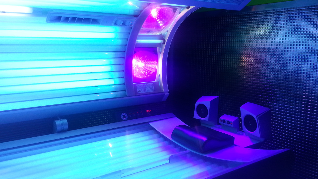 open tanning bed with blue and purple lights