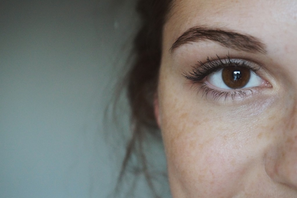 woman's eye up close with cheek freckles