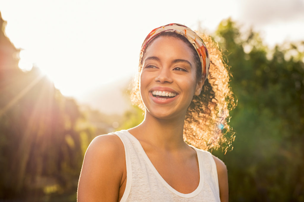 woman with colorful headband smiling in the sun
