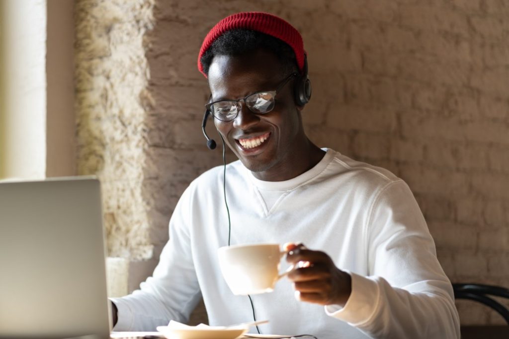 man with headset smiling with coffee