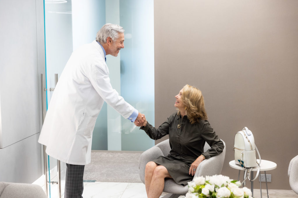 Dr. Pearlman greets a female patient to discuss her blepharoplasty cost in NYC