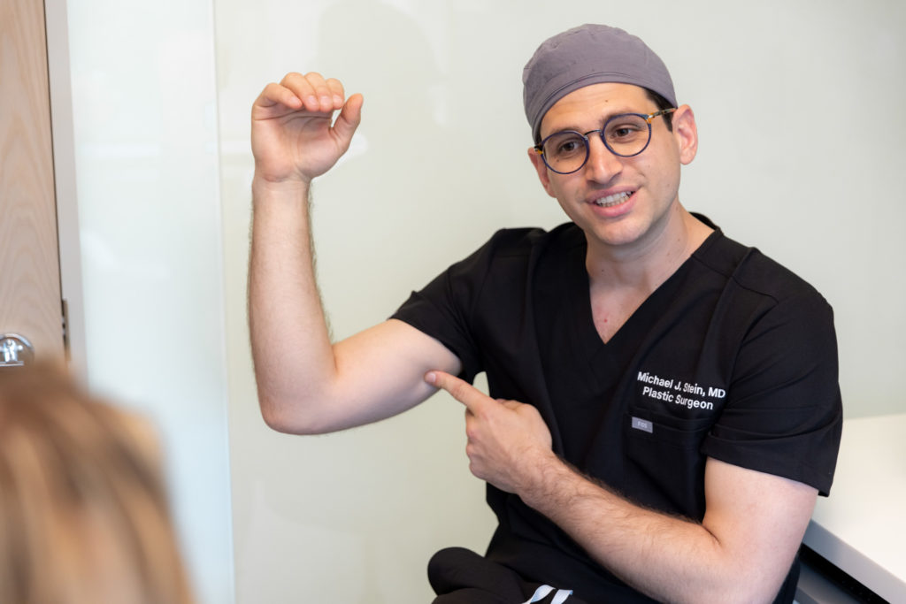 Dr. Stein Surgical Consultation specialist pointing to his upper arms
