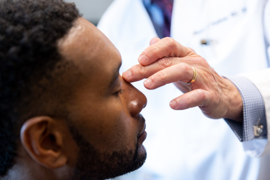 Dr. Pearlman touching patient's nose during rhinoplasty consultation