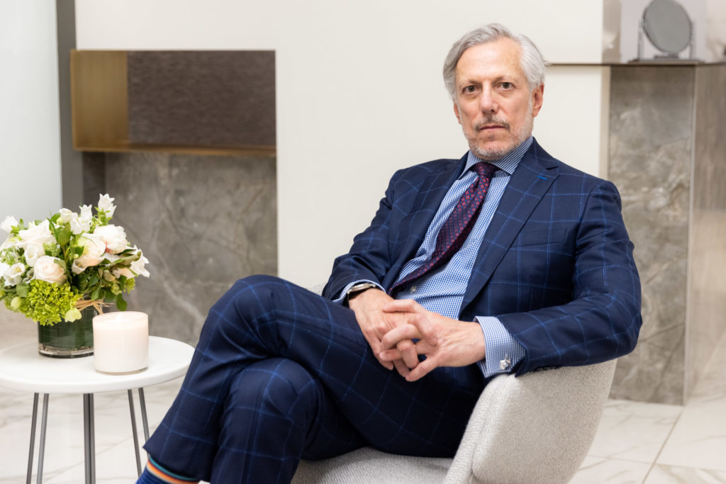 Dr. Pearlman sitting in chair by flowers