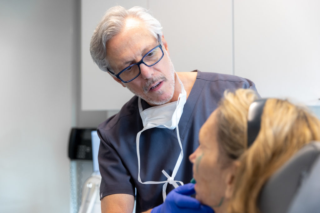 Dr. Pearlman inspects a female patient's eyes to determine the best approach for hooded lid surgery in NYC