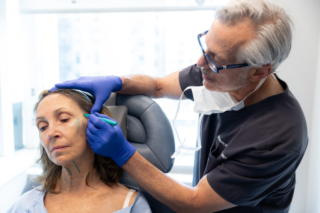 Dr. Pearlman makes surgical marks on patient for facelift