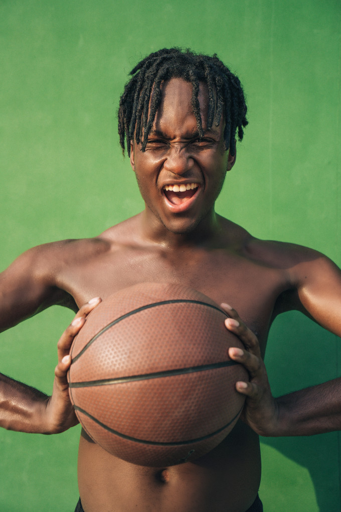 excited shirtless man holding a basketball