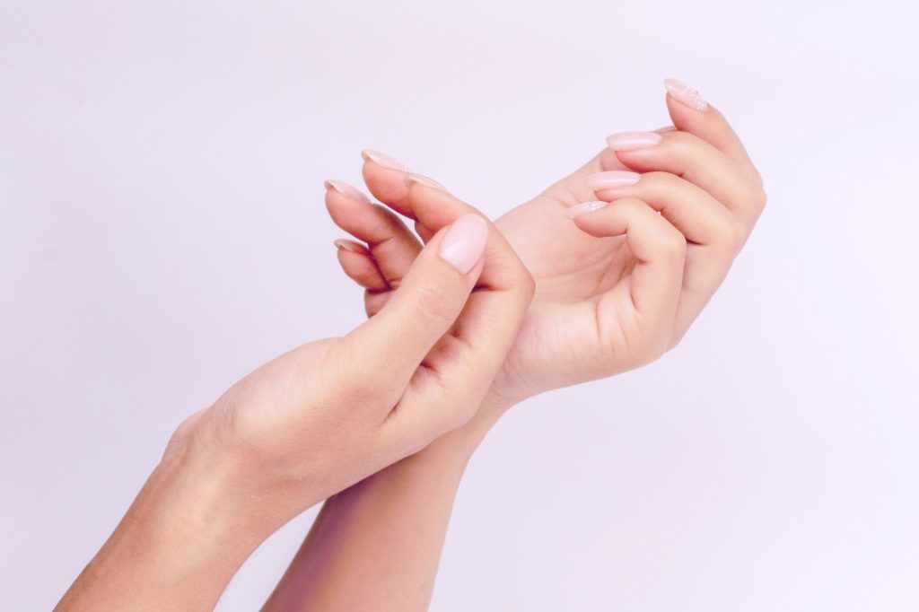 woman's hands with light pink manicure