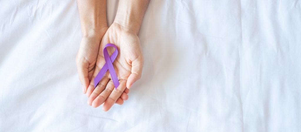 woman holding a purple ribbon